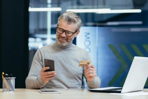 A guy using cellphone after decide between Online vs Traditional Banks.