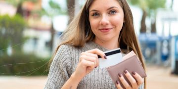 Woman using credit card after find out the differences between Secured and Unsecured Credit Cards.