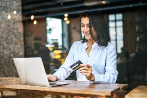 A girl using credit card while read the differences between Secured and Unsecured Credit Cards.