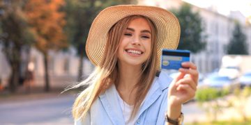 Moça feliz usando um Citi Custom Cash Credit Card.