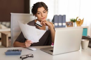Woman studying to choose between checking or savings account.
