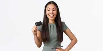 Woman holding her United Club Infinite card.