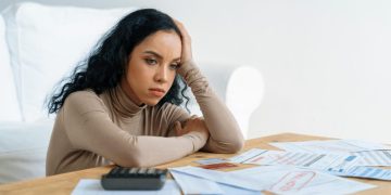 A sad woman trying to learn how to reduce debt.